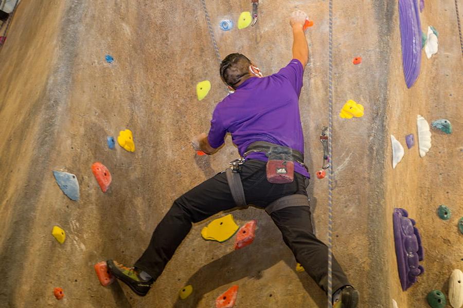 Student on the climbing wall in harness