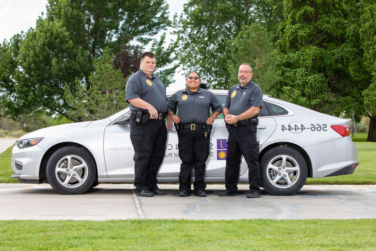 Three SJC Campus Security Officers stand in front of patrol car